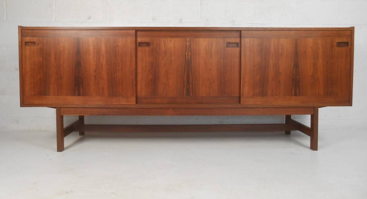 Nicely detailed sliding door credenza in rosewood with finished back for 360 application. Please confirm item location (NY or NJ) with dealer.