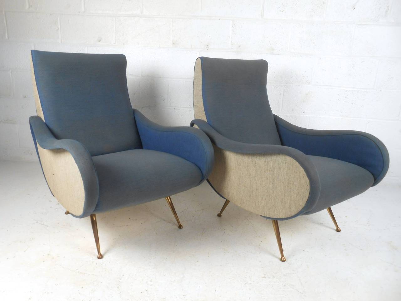 This beautiful pair of vintage Italian armchairs features the ultimate mix of comfort and style. Lounge back, tapered metal legs, and uniquely shaped arms make these chairs the perfect addition to any vintage modern interior. Please confirm item