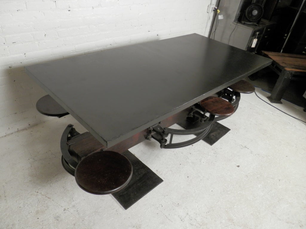 Fantastic cast iron table with six swing-out stools. Exposed bolts and hardware for dramatic effect.