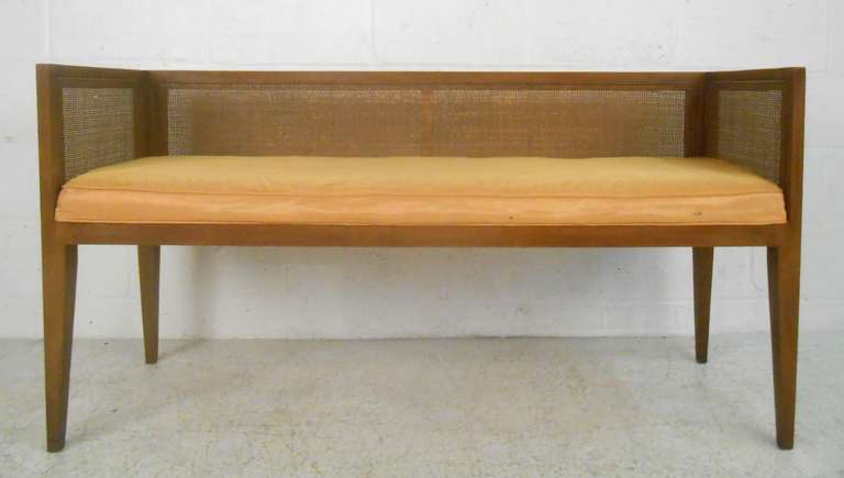 This midcentury window bench features a walnut frame, cane back/sides with upholstered seat.  Please confirm item location (NY or NJ).