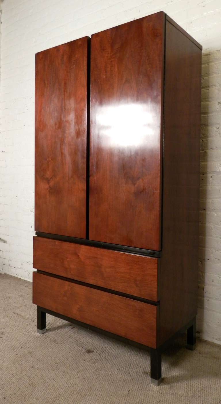 Elegant vintage modern chest with large double door cabinet and wide bottom drawers. Ample room for storage including drawers and six cubbies. Attractive book-matched walnut grain with black trim behind, giving a handsome, stream-lined modern