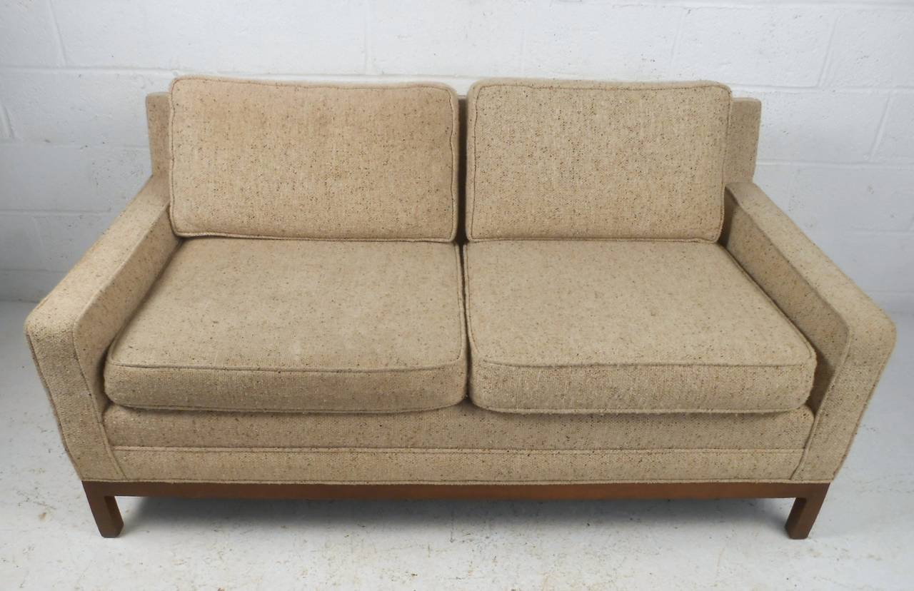 This unique Knoll love seat features a unique walnut frame, vintage fabric, and comfortable upholstery. Matching three seat sofa available, please confirm item location (NY or NJ).
