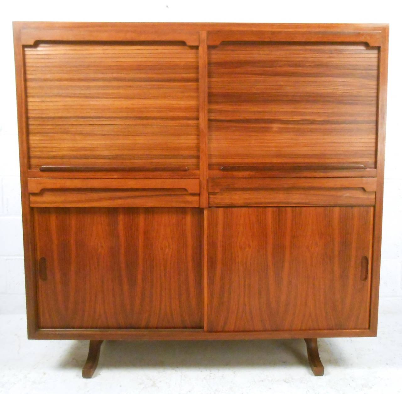 This stylish rosewood cabinet makes the perfect vintage dry bar for any setting. Interior cabinets offer adjustable shelves with plenty of space for liquor or general storage, while its unique sculpted base adds to its appeal. Unique vertical