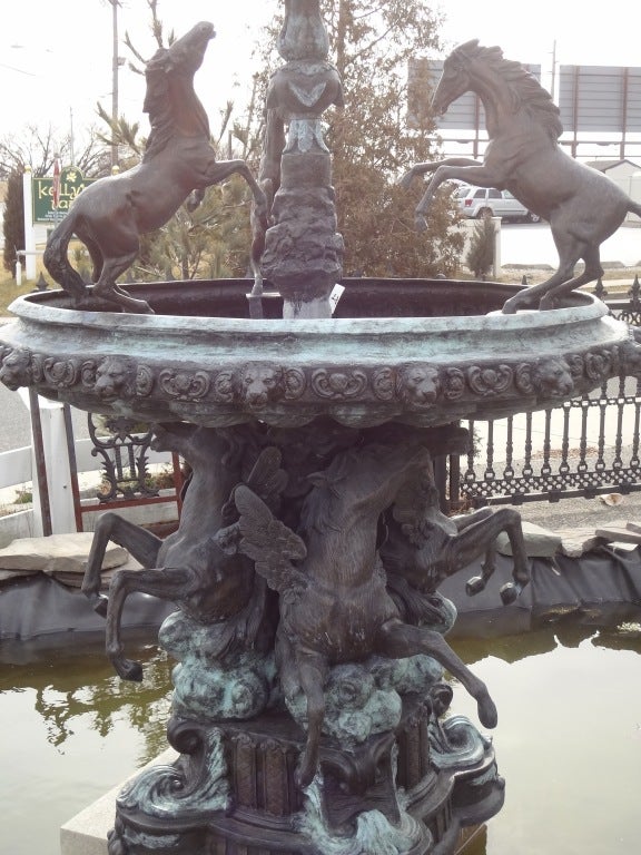 Stunning and elaborately detailed bronze, two-tier, horse themed fountain. Water cascades from the 1st to 2nd tier and streams out the 18 lion heads around the perimeter of the large bowl. Please confirm item location (NY or NJ) with dealer.