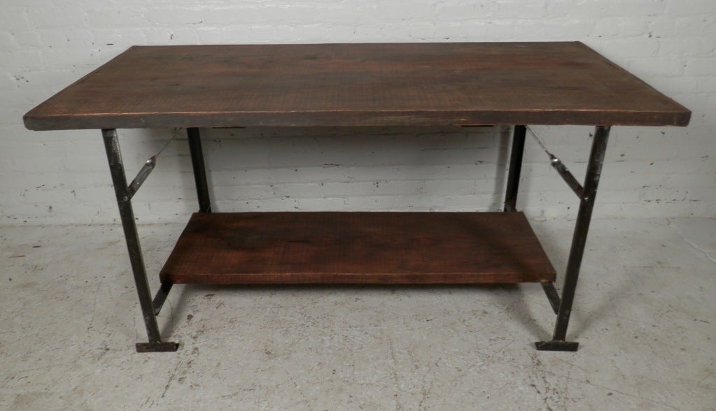 Vintage work table made of heavy cast iron and solid wood. Exposed bolts for industrial look.