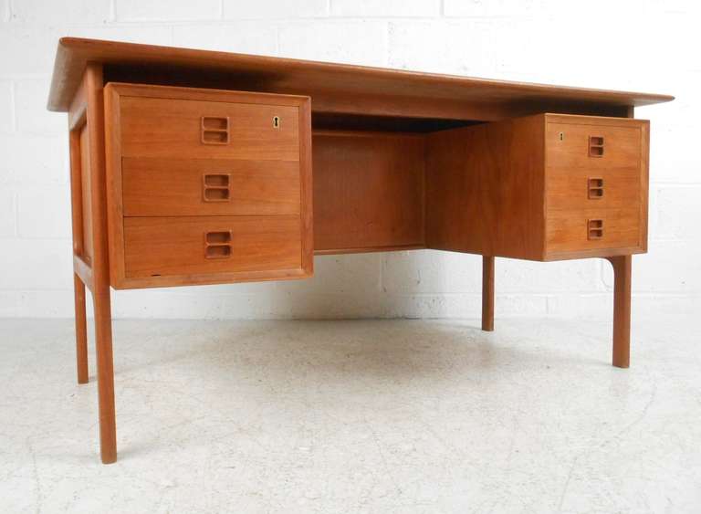 Danish teak double sided kneehole desk with two banks of drawers at front, and open bookshelves on back. Design in the style of Arne Vodder for Sibast. Please confirm item location (NY or NJ) with dealer.