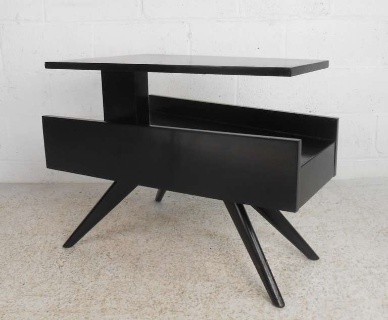 Uniquely designed trapezoid shaped side table with floating top, storage drawer and flared legs. Black lacquer finish. Please confirm item location (NY or NJ) with dealer.