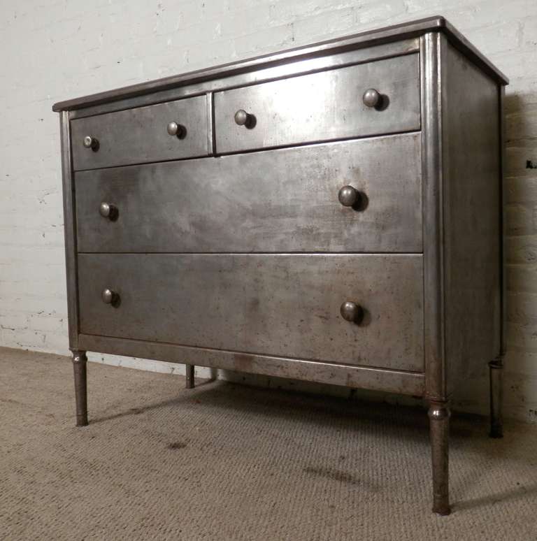 All metal four drawer dresser done in an industrial style, bare metal look. The dresser shows oxidation, pit marks, which are all part of the rough metal finish.

(Please confirm item location - NY or NJ - with dealer)