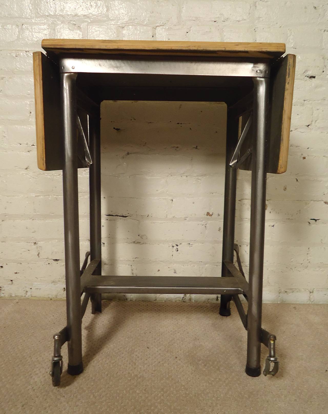 Vintage metal rolling table with extending wood top. Restored in a bare metal style finish. Makes a great side table for any modern home.
Extended width: 35.5"

(Please confirm item location - NY or NJ - with dealer)