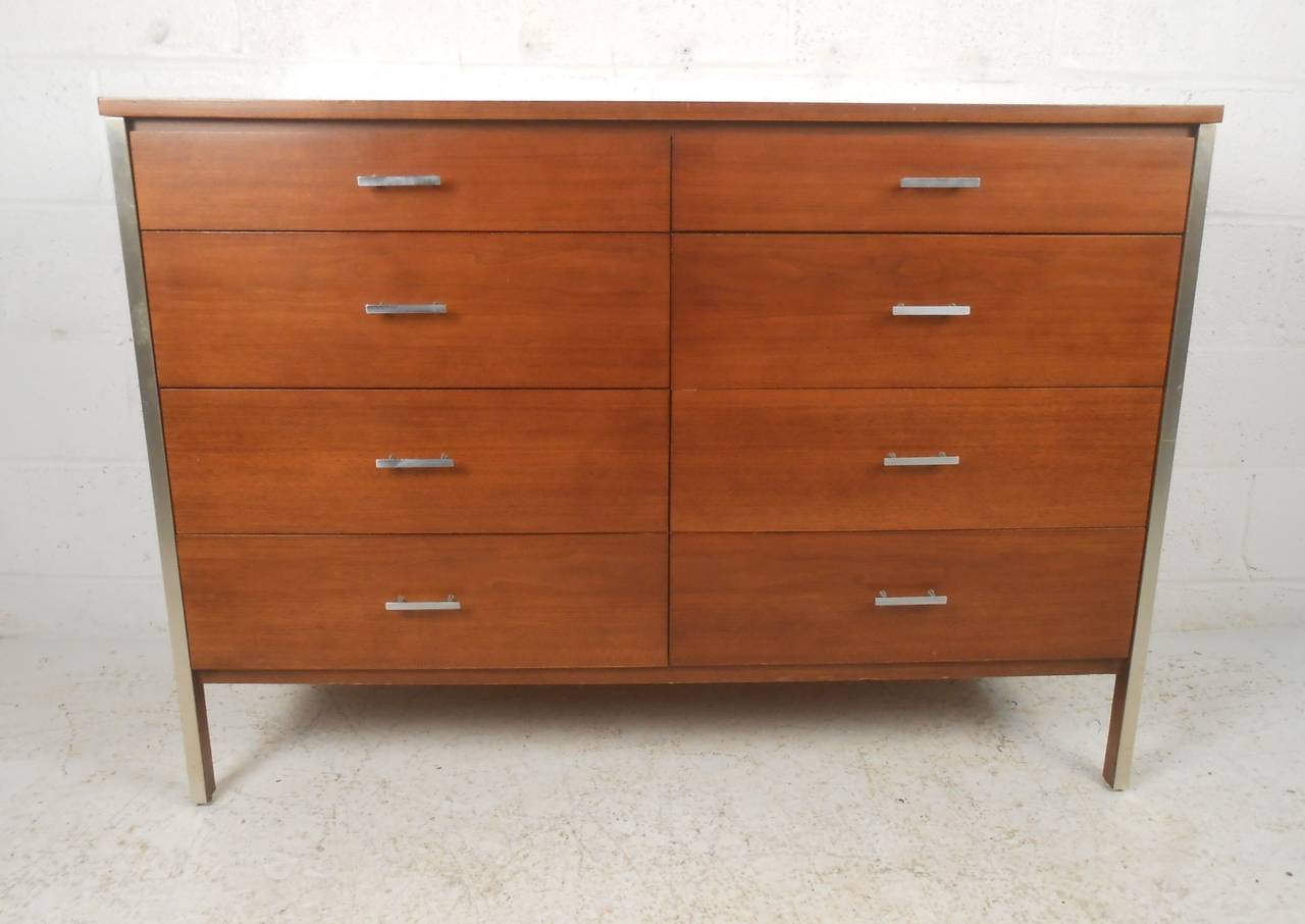 Classic Paul McCobb eight-drawer walnut dresser with Mid-Century Modern styling. Spacious drawers make bedroom organization a stylish affair, while the mix of vintage wood finish and aluminum trims make a striking addition to any interior. Please