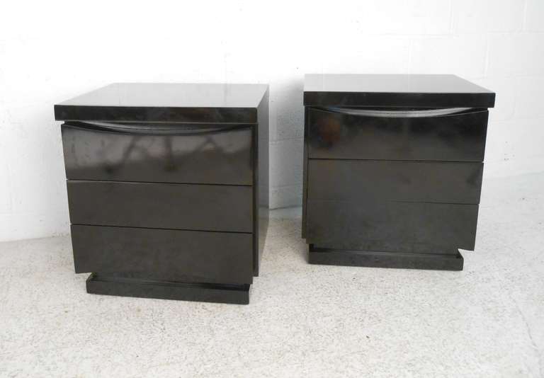 This pair of nightstands by American of Martinsville feature a beautiful black lacquer finish with Mid-Century Modern styling with solid three drawer construction. Vintage end tables add elegant storage to home or office. Please confirm item