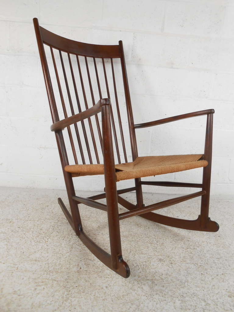 This midcentury spindle back rocking chair features a solid walnut construction and woven paper cord seat in the manner of Hans Wegner's famous J-16 rocker. Very comfortable with style and form.

Please confirm item location (NY or NJ) with dealer.