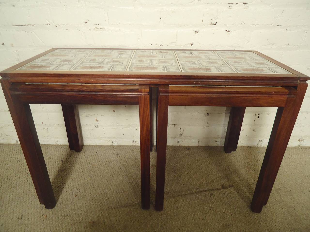 Attractive rosewood table set with decorative tile tops. Two side tables nest within the coffee table.
Side Tables: 14