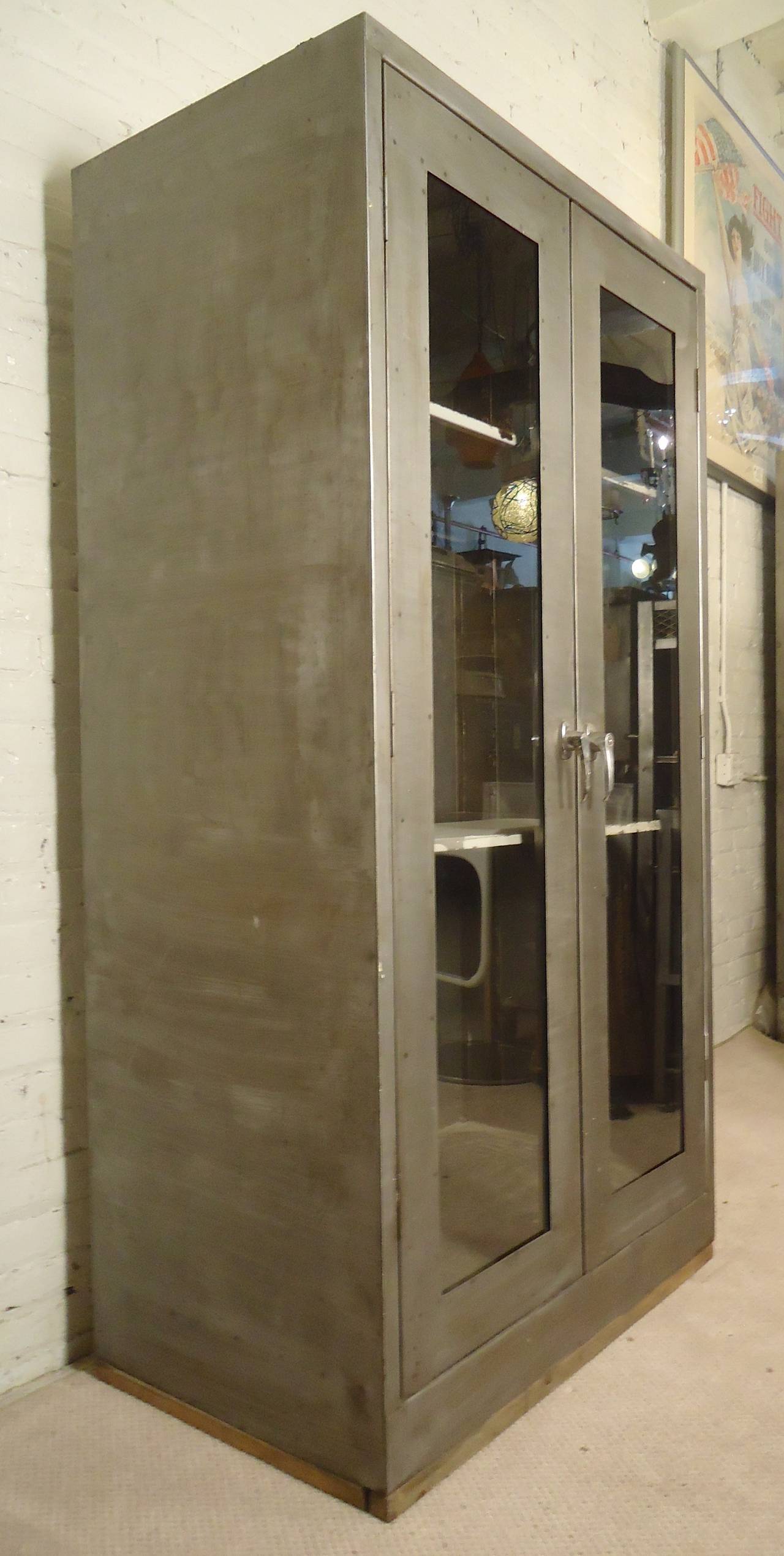 Massive vintage cabinet with latching glass front doors. Comes with two metal shelves, but can accommodate many more. Most likely used for hospital or factory storage, now restored for modern home use.

(Please confirm item location NY or NJ with
