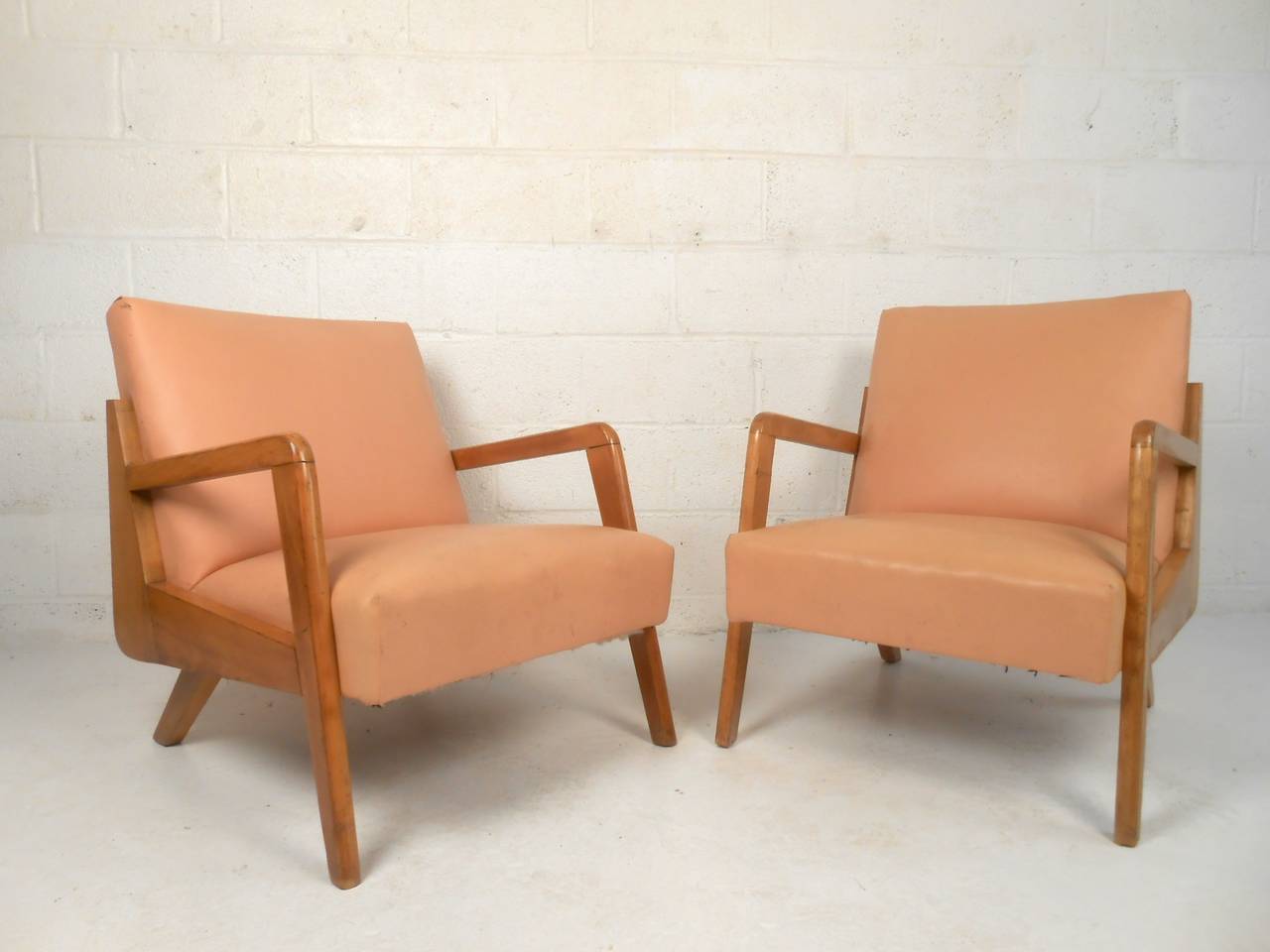 Stunning Mid-Century Modern armchairs with tapered legs and vinyl seats. Brass nailheads trim the back accentuate the vintage atomic design of the shapely seat frames. Ideal lounge chairs for home living room or business lounge area. 

(Please