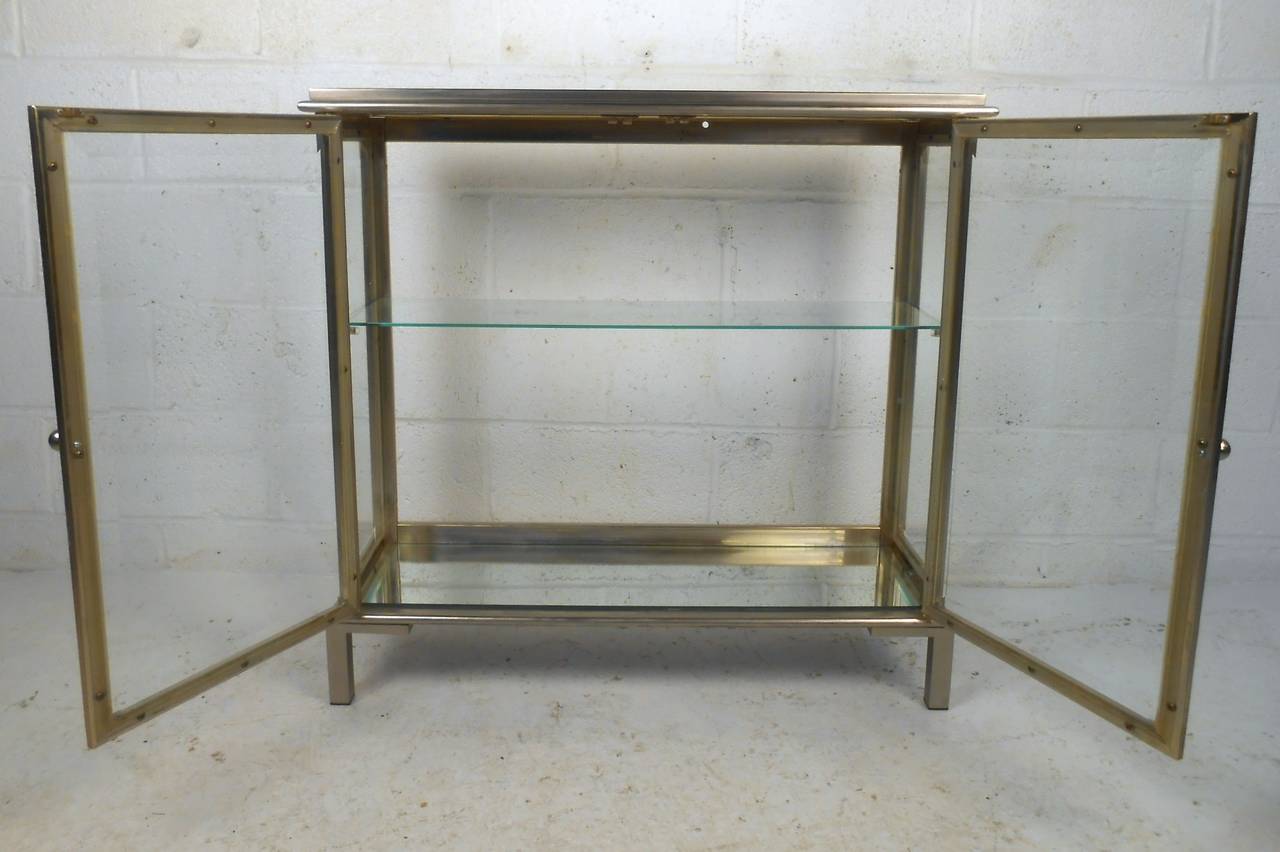 This unique display cabinet features mirrored top and bottom panels, sturdy metal construction, and stylish two-tone design. Perfect addition to home or business, please confirm item location (NY or NJ).