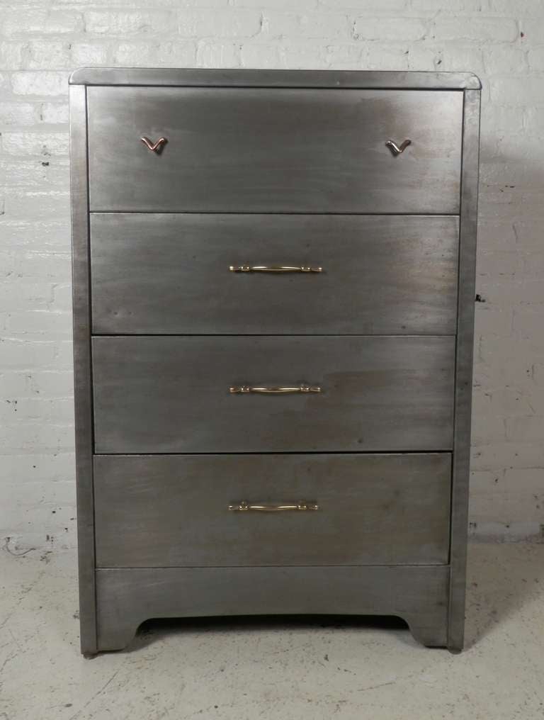 Norman Bel Geddes designed four drawer dresser by Simmons. Vintage modern design with sleek lines, deep drawers and brass hardware. The original paint has been stripped, sanded and lacquered for a striking industrial look.

(Please confirm item