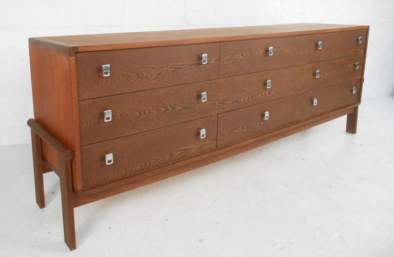 This beautiful Danish modern nine drawer dresser is constructed of rosewood and teak and features polished chrome pulls and a sculpted teak base.  Please confirm item location (NY or NJ) with dealer.