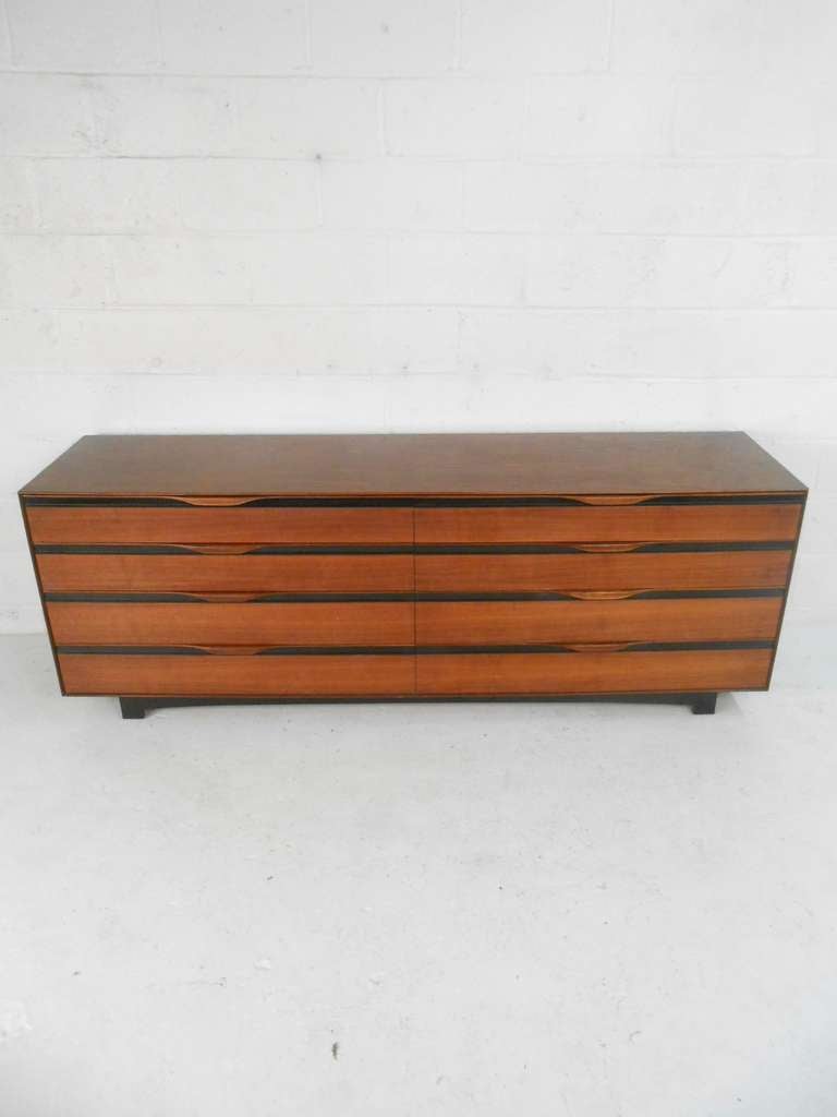 A five-piece Mid-Century Modern bedroom suite by John Kapel for Glenn of California. Featuring highboy dresser and long low dresser both with eight drawers, and two single drawer nightstands with headboard. Please confirm item location (NY or NJ)