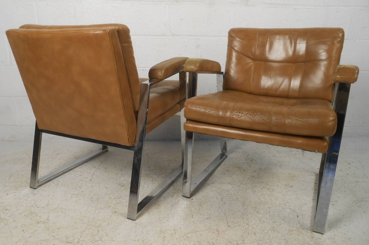 Pair of chrome frame midcentury armchairs by the Patrician Furniture Co., High Point, N.C. This stylish retro pair of tufted vinyl armchairs features sled leg Milo Baughman style design, upholstered chrome frames, and make a beautiful addition to