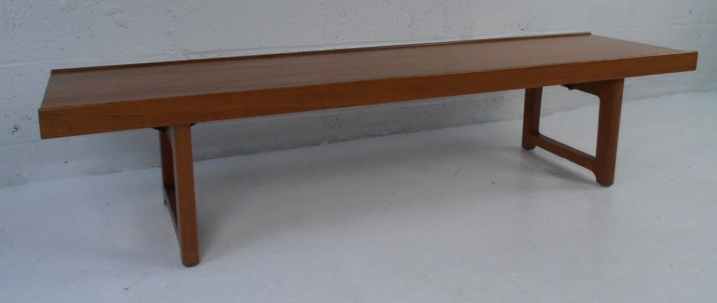 This stylish Torbjørn Afdal bench style coffee table with raised edges and sled legs makes the perfect midcentury cocktail table for home or business. Scandinavian Modern design with choice solid teak construction. Please confirm item location (NY