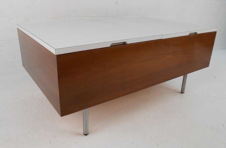 Mid-century modern coffee table with hinged white laminate doors, designed by George Nelson, circa 1950s. Please confirm item location (NY or NJ) with dealer.