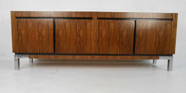 Dramatic rosewood pattern, Mid-Century four-door credenza with storage drawer. Please confirm item location (NY or NJ) with dealer.