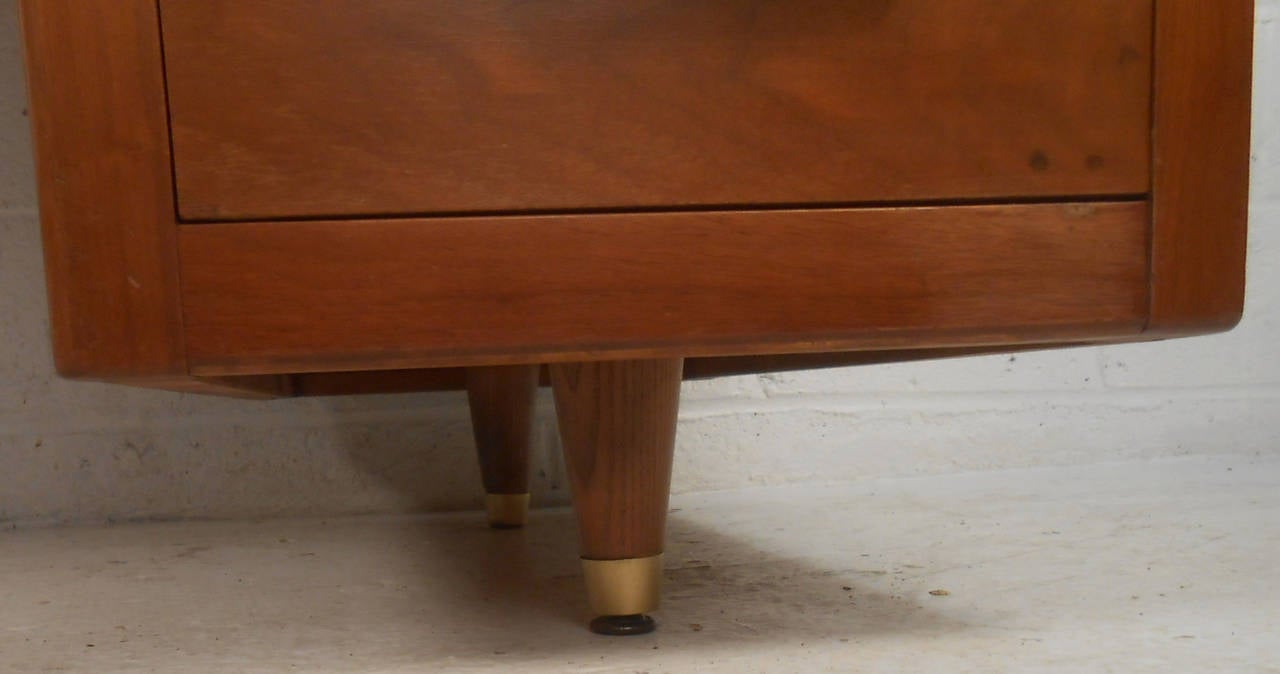 This midcentury American made desk features a rich walnut finish, three drawers for storage, and brass trim on handles and legs. Designed for John Widdicomb inc., this striking desk is the perfect addition to any office setting. 

(Please confirm