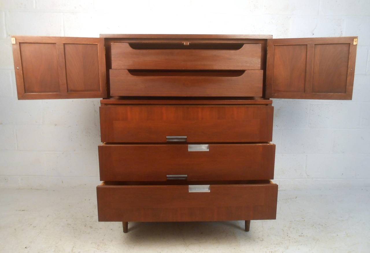 This unique vintage dresser offers five spacious drawers for storage, unique drawer pulls, and wonderful walnut finish. Ideal midcentury highboy dresser for bedroom storage. Please confirm item location (NY or NJ).