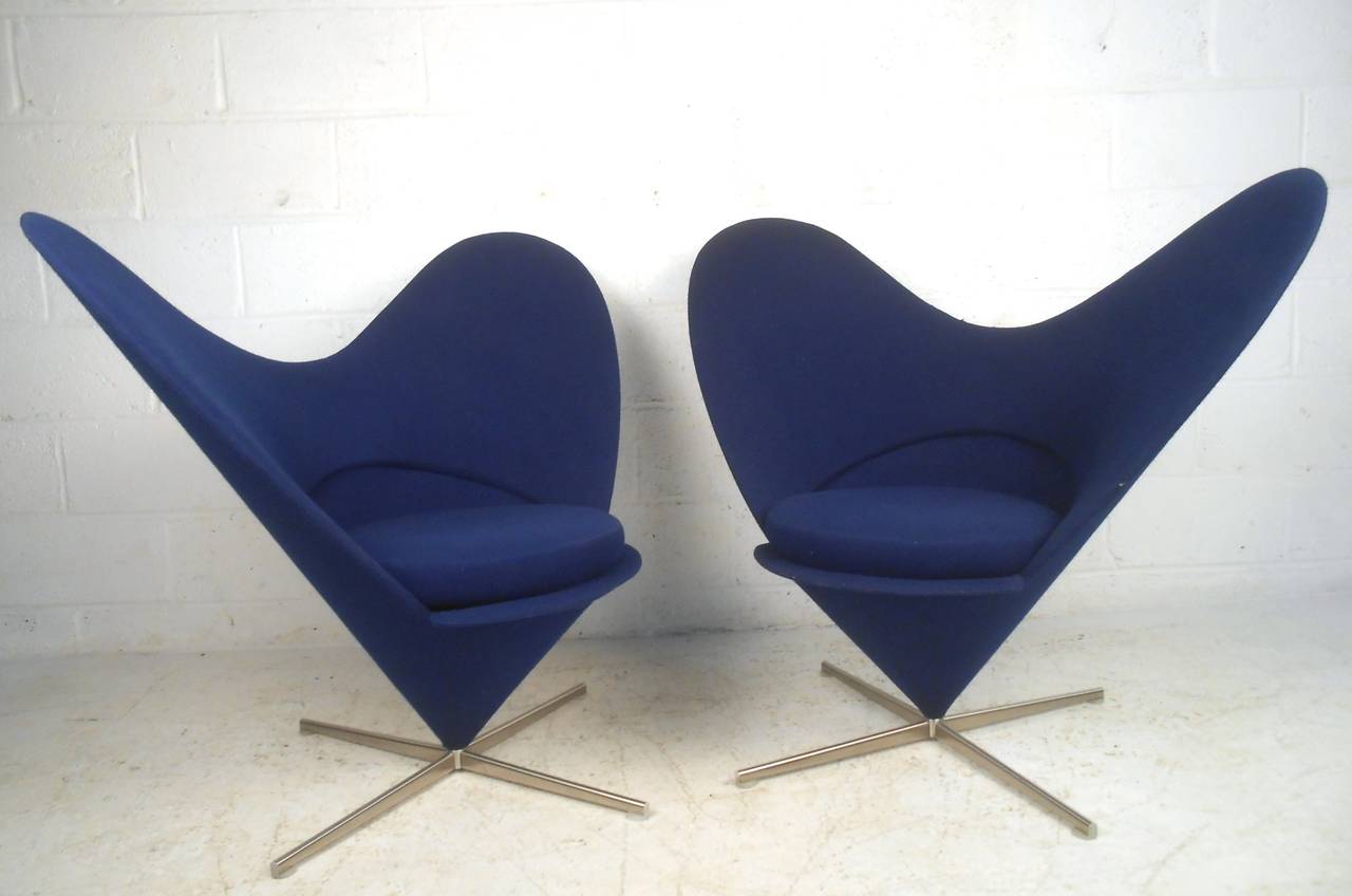 This fantastic pair of Scandinavian Modern style lounge chairs make an impressive stylistic addition to any setting. Designed after HW Klein with unique sculpted wingback seats and swivel base, this elegant retro pair truly stands out. Please