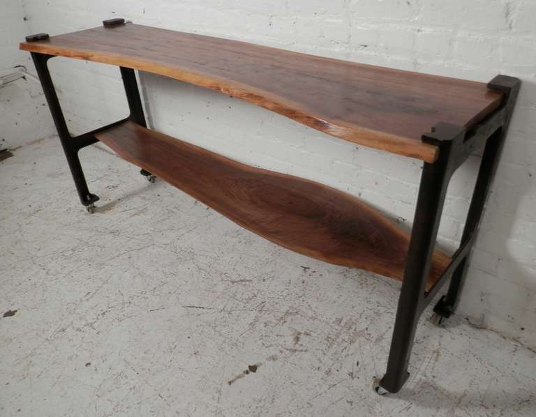 Unique console table with two one of a kind free edge shelves resting in solid iron frames. Sits on locking casters for easy mobility. Attractive walnut planks with distinct grain and live edge patterns.

(Please confirm item location - NY or NJ -
