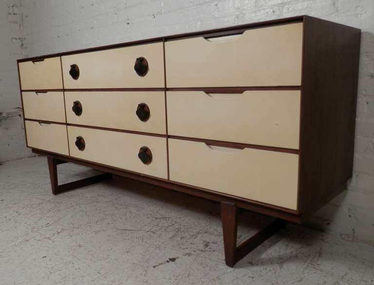 Mid-century modern furniture by Stanley featuring white front drawers accenting the deep walnut wood body. Spacious drawers with over-sized brass spade shaped hardware that add a whimsical style. A unique find.
Highboy and nightstand also