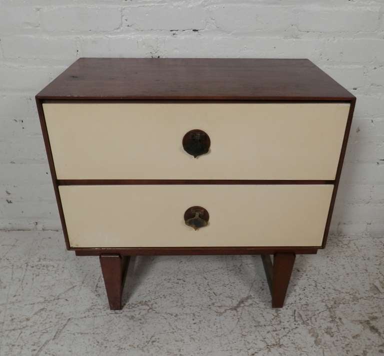 Mid-century modern furniture by Stanley featuring white front drawers accenting the deep walnut wood body. Spacious drawers with over-sized brass spade shaped hardware that add a whimsical style. A unique find.
Highboy and dresser also