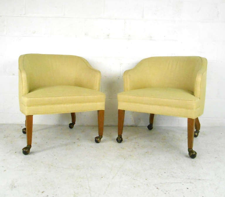 This unique pair of midcentury barrel back club chairs add vintage style to home or business. Hardwood legs with casters for ease of movement. Please confirm item location (NY or NJ).
