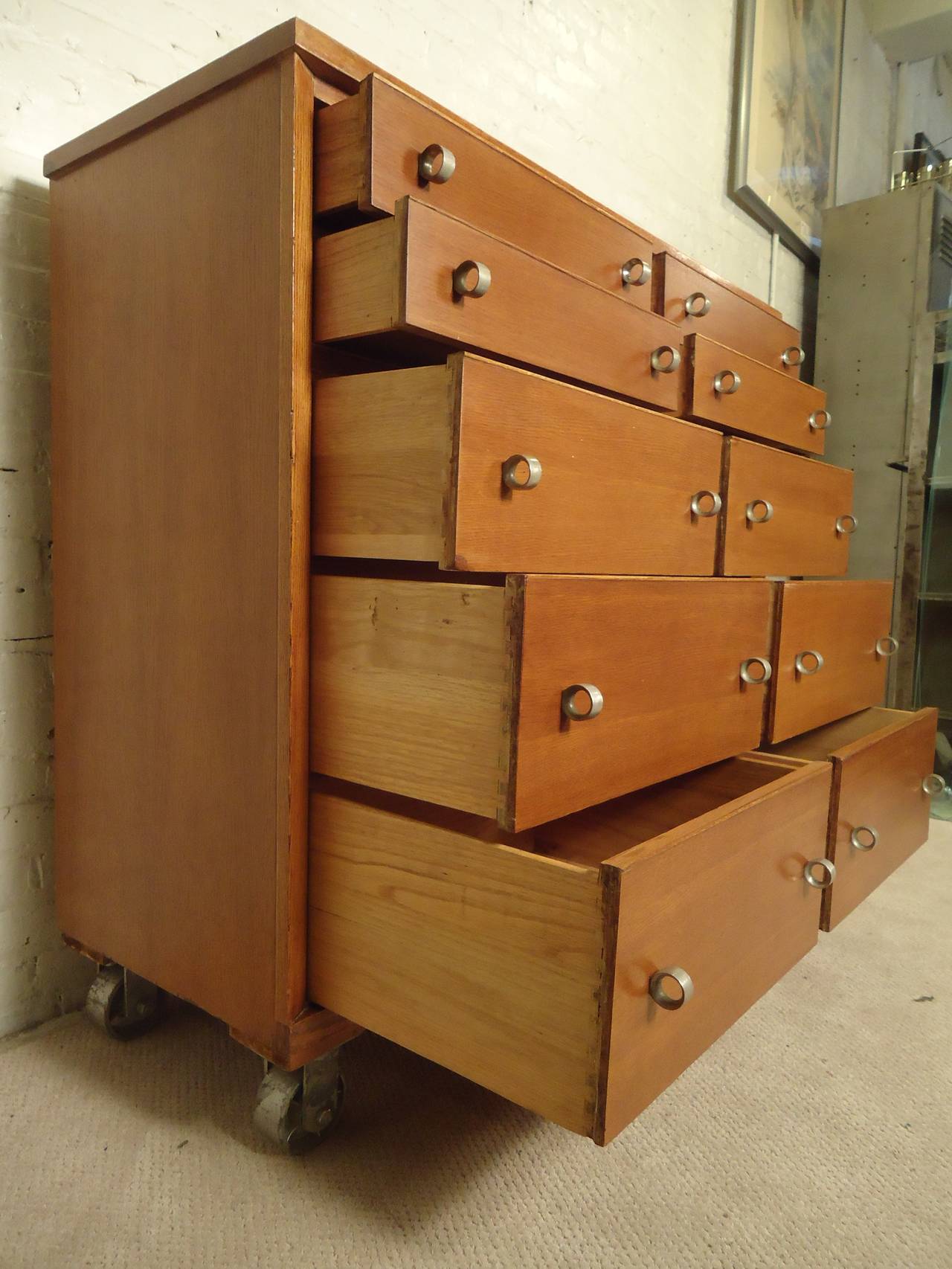 Rare tall chest of drawers with metal ring hardware and complimenting metal casters. Ten total drawers, golden mahogany coloring, ample storage.

(Please confirm item location - NY or NJ - with dealer)