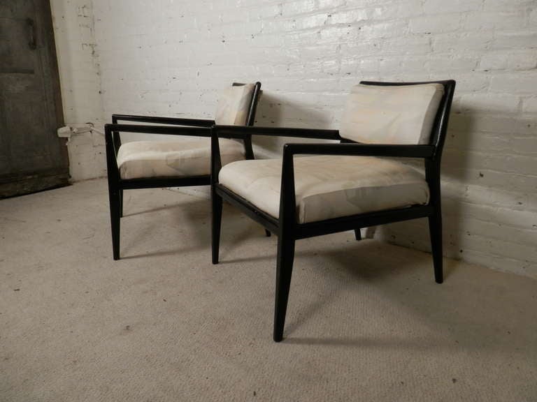 Pair of vintage armchairs with drastic angular lines. Deep seat accentuates the long angled arms, in addition to the tapered legs. In need of recovering, but the unique frame is a one of a kind find!

(Please confirm item location - NY or NJ -