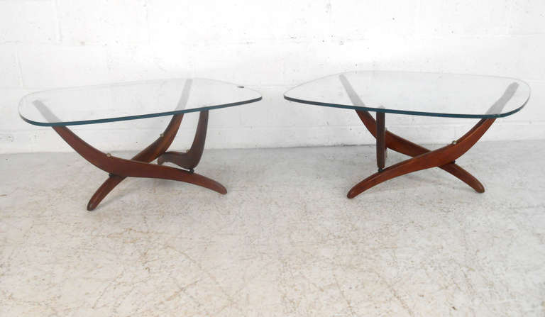 This unique pair of glass top end tables features stylish and sturdy walnut frames and unique chrome accents by Forest Wilson. Beautiful midcentury design adds a sculptural elegance to any interior. Please confirm item location (NY or NJ).