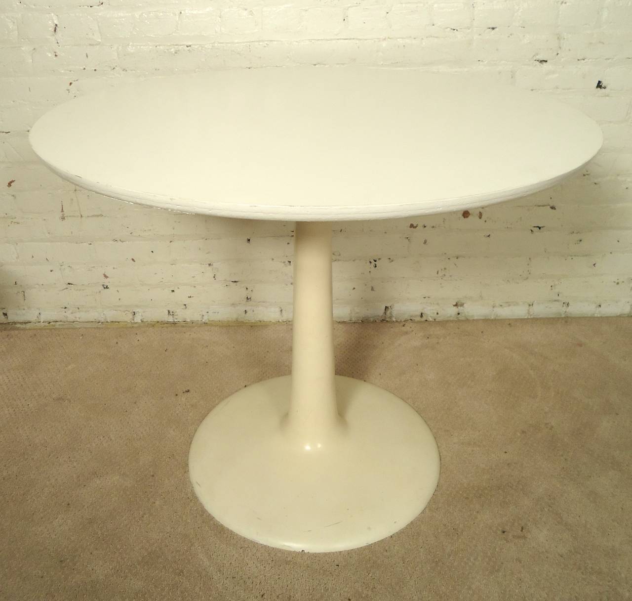 Four lucite back swivel dining chairs and round white table, all with matching tulip bases. Vinyl seats, elegant "wing" backs, graceful tulip bases. 
Table: 36"dia 29"h

(Please confirm item location - NY or NJ - with dealer)