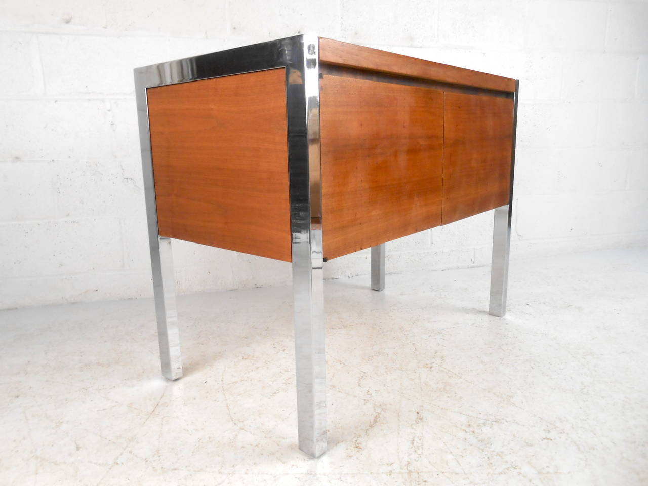 This midcentury cabinet features solid walnut construction, a chrome frame, and two door design with adjustable interior shelf which offers ample storage and a modern accent to any home or office space.

Please confirm item location (NY or NJ)