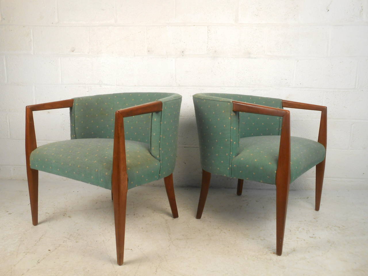 This pair of midcentury lounge chairs feature upholstered barrel back design and solid walnut frames which offer a modern flare and comfortable seating to any home or office space. 

Please confirm item location (NY or NJ) with dealer.