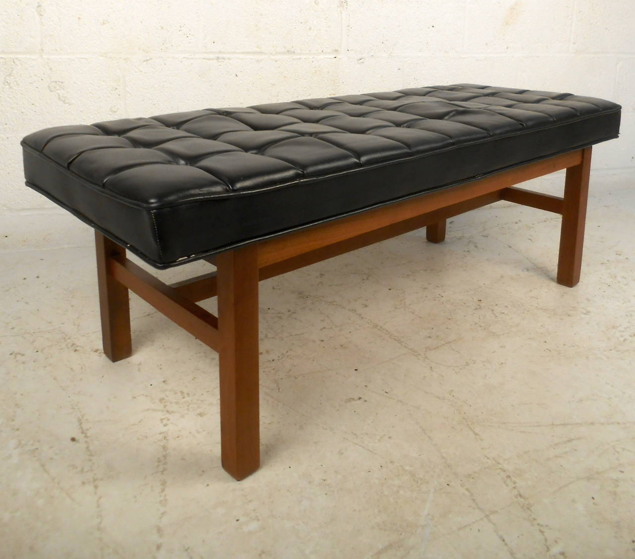 This Mid-Century bench features a tufted black vinyl upholstery and solid walnut frame which offers a comfortable modern access to any home or office space.

Please confirm item location (NY or NJ) with dealer.