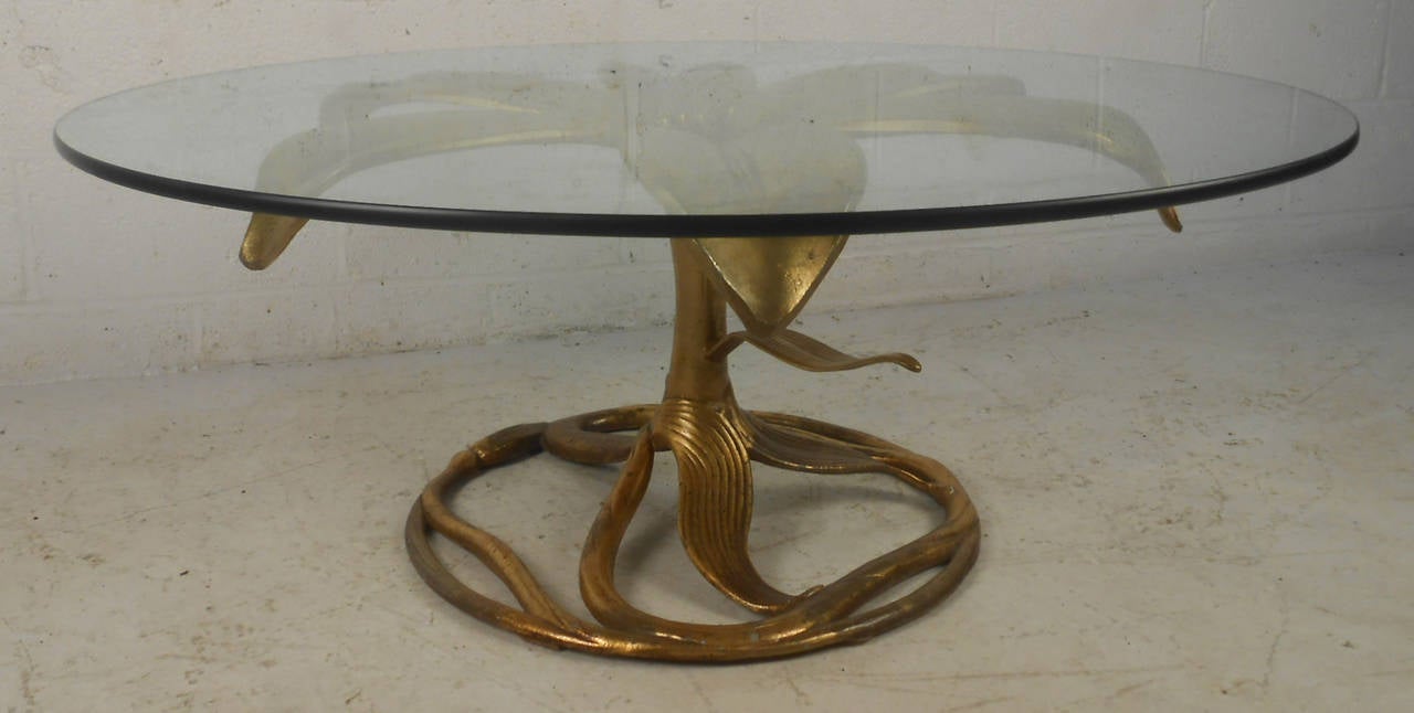 Vintage Arthur Court coffee table, features sculpted gold tone metal in the shape of a lily and glass top.

(Please confirm item location - NY or NJ - with dealer)