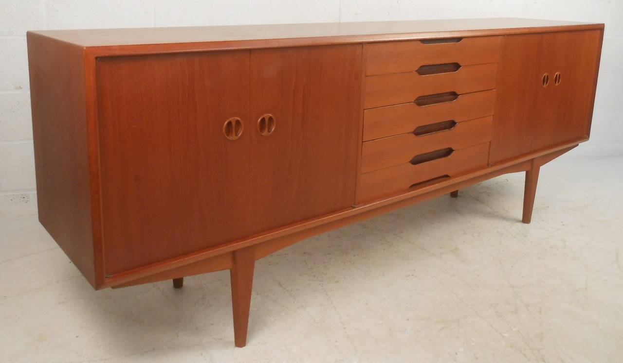 Danish modern teak sideboard or credenza with five drawers and two storage compartments with adjustable shelves. Please confirm item location (NY or NJ) with dealer.