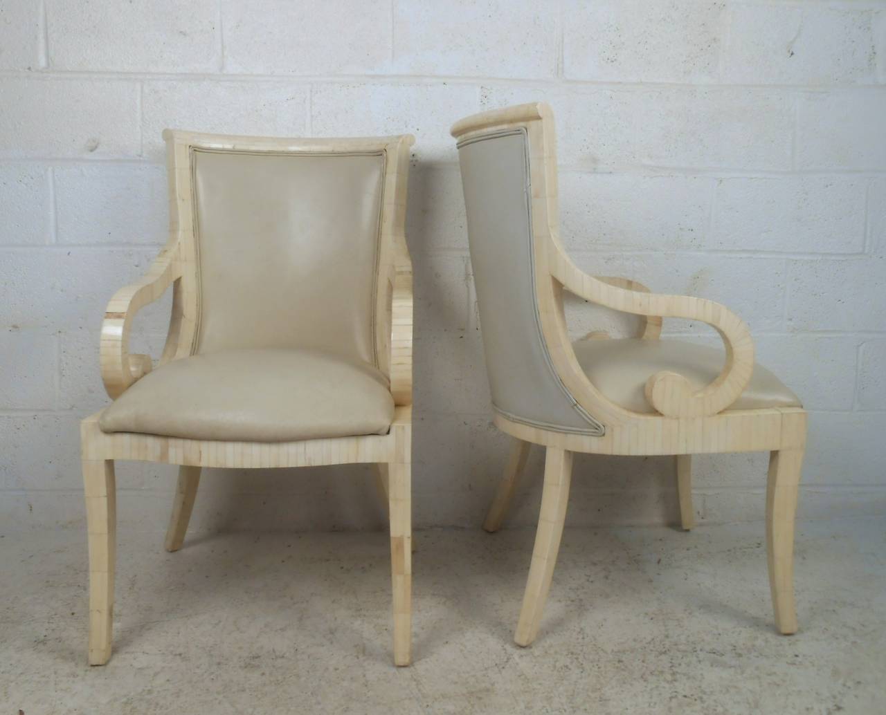 This pair of scroll arm side chairs features a tessellated bone finish, high back design, and unique vintage design of Enrique Garcel. Please confirm item location (NY or NJ). 