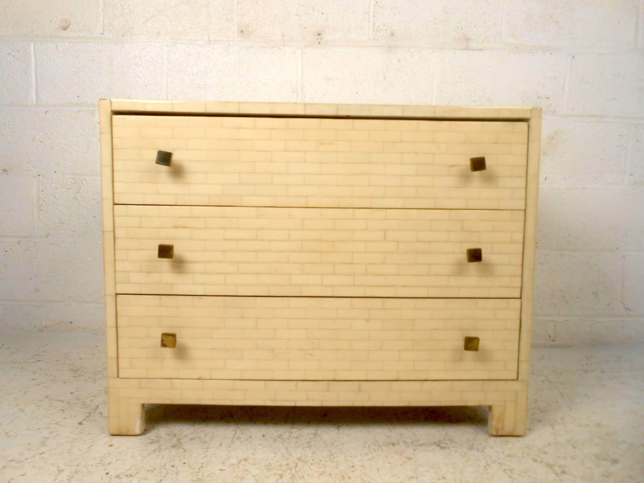 This mid century three drawer dresser features a white lacquer finish, unique brass pulls, and sturdy construction which offer a modern flare and ample storage to any home or office space.

Please confirm item location (NY or NJ) with dealer.