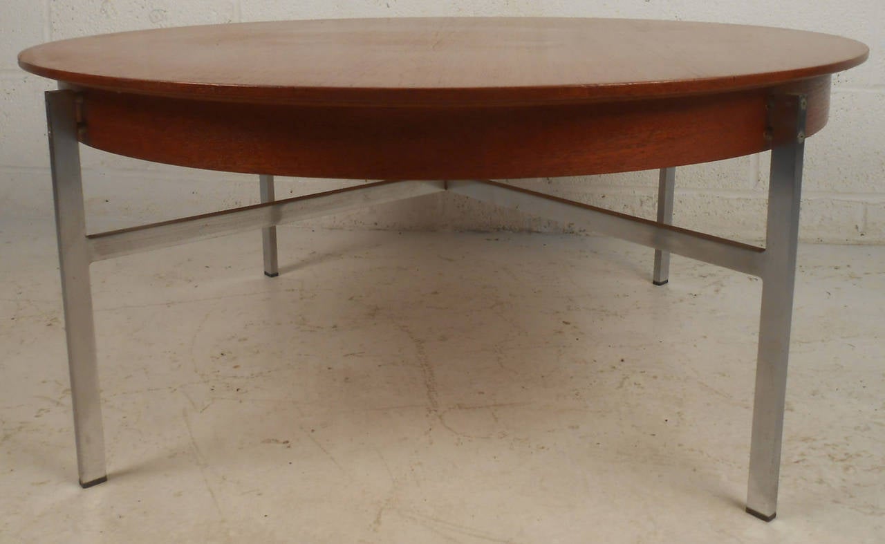 Vintage 1960s coffee table, features modern metal base and a round top with beautiful teak grain.

(Please confirm item location - NY or NJ - with dealer)