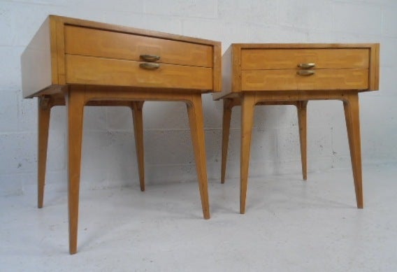 Striking pair of atomic modern end tables feature unique inlaid drawer fronts, stylish brass handles and slender tapered legs. Beautiful mid-century modern design and ideal height for use as sofa side tables or nightstands. Please confirm item