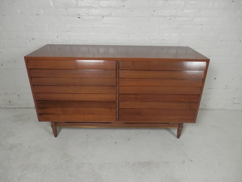 Merton Gershon designed mid-century modern dresser for American Of Martinsville. Stylish louvered drawers with brass trim along the bottom.
