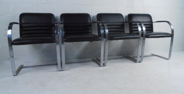 This matching set of four heavy gauge chrome frame chairs feature black leather upholstery, stylish cantilever frames, and plush and comfortable padding. Manufactured by Preview Furniture, High Point, N.C. these mid-century modern chairs make a