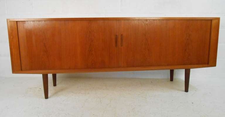 Beautifully crafted Poul Hundevad tambour door credenza with quality birch interior, teak exterior finish, and adjustable shelves. Danish control emblem and makers mark visible. Stylish midcentury storage credenza or sideboard for any interior.